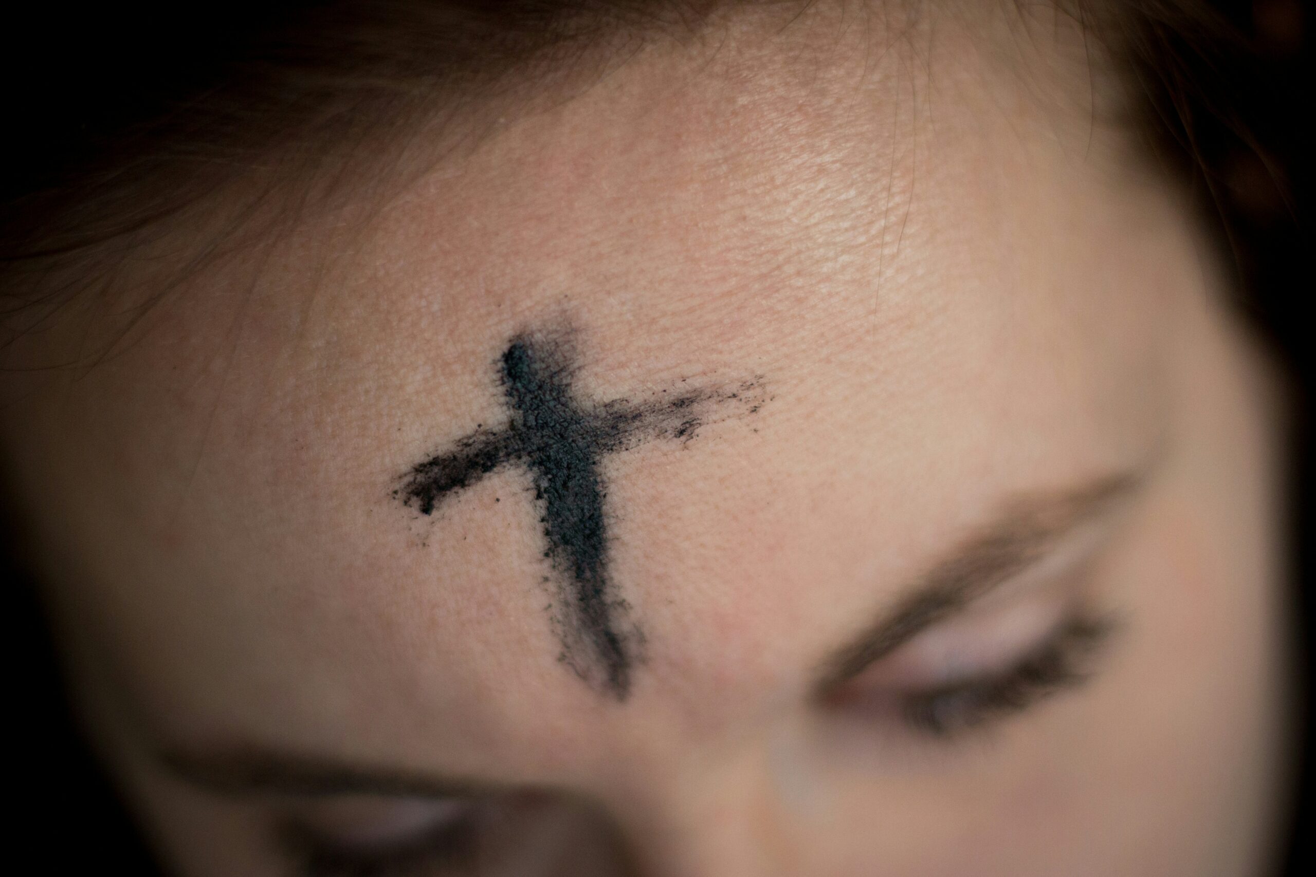 A woman's forehead with ashes in the shape of a cross